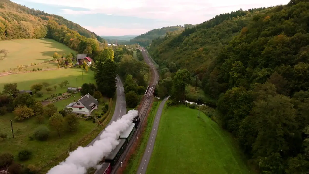 Aerial view of a steam train passing through an autumn landscape