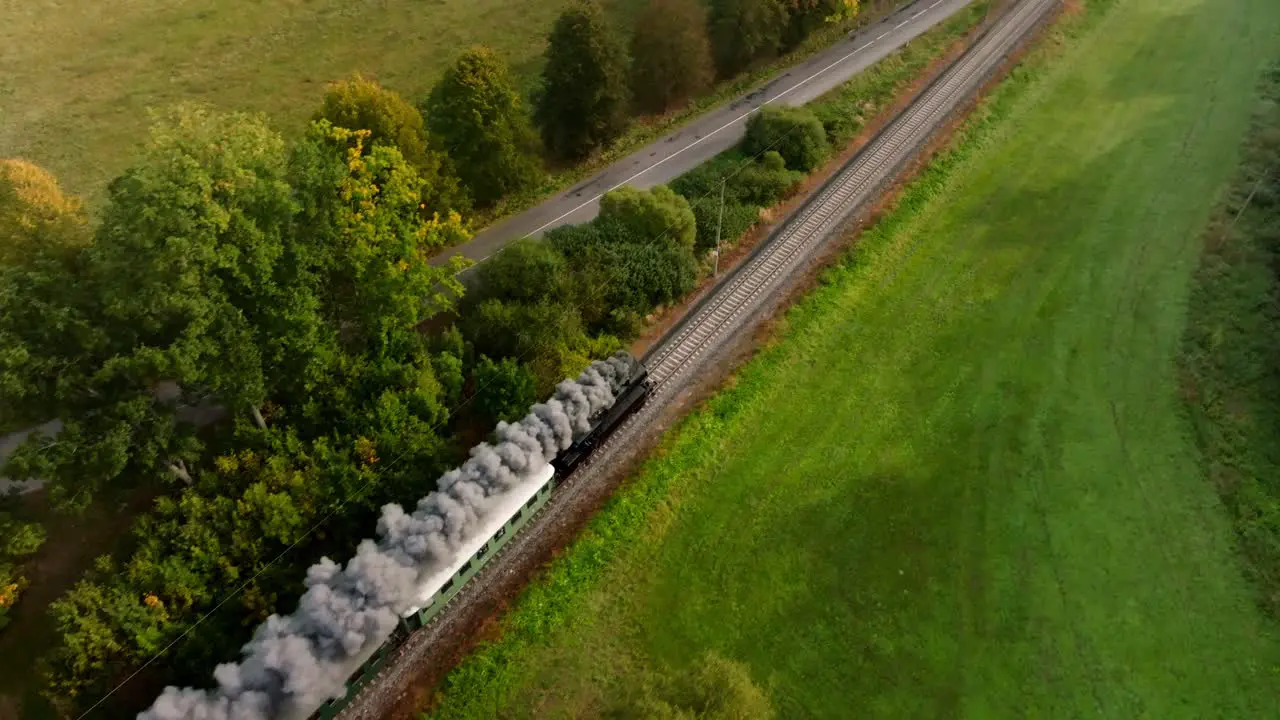 Aerial view of a steam train driving in an autumn landscape