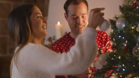 Tracking Shot Approaching Couple Decorating Christmas Tree Together