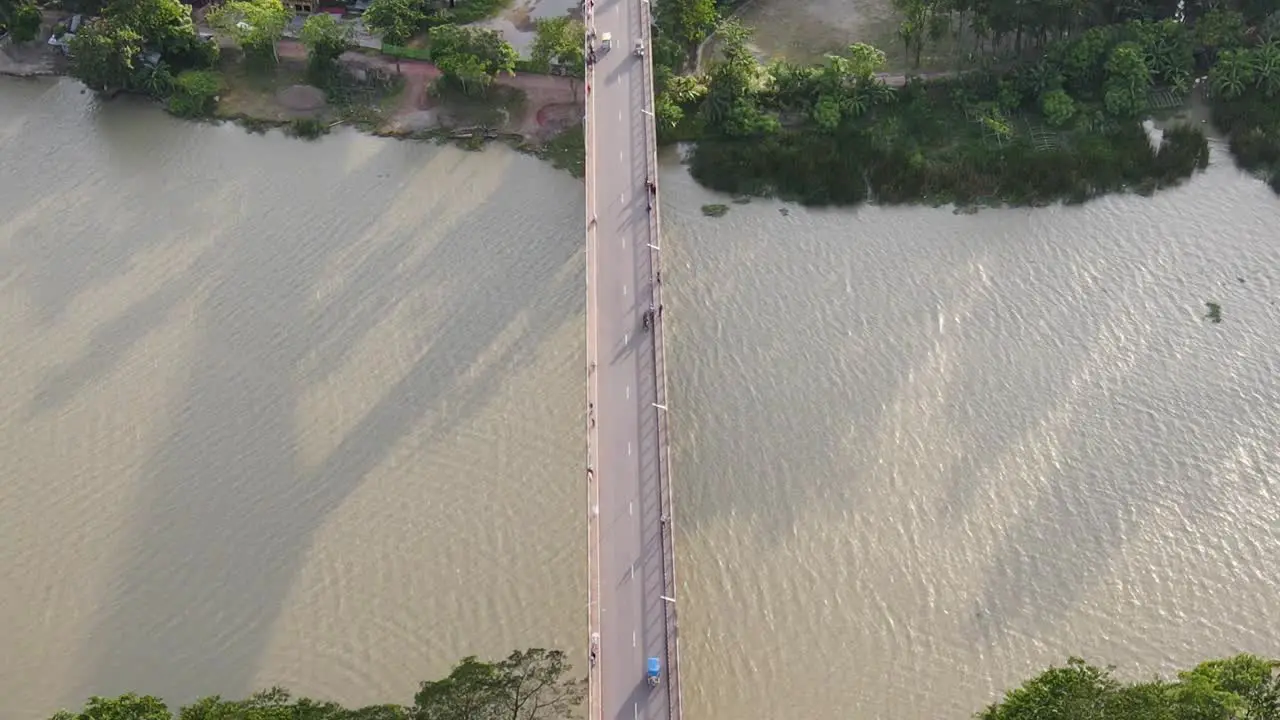 Topdown view Follow vehicles driving along bridge road over Muddy river Bangladesh