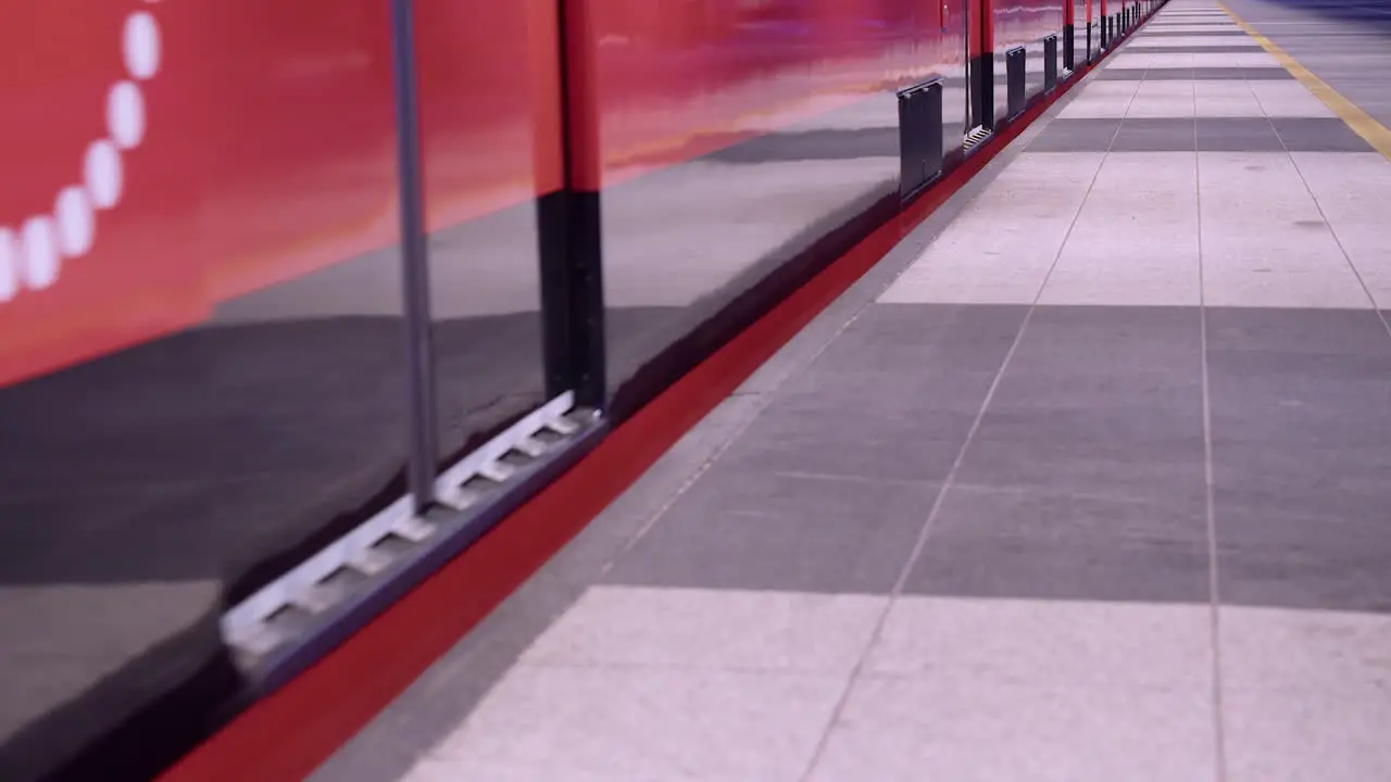 Low angle Clean red subway train doors close and train leaves station