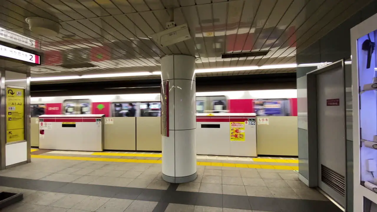 Slow panning shot of train leaving subway platform in Shibuya Station in Tokyo Japan