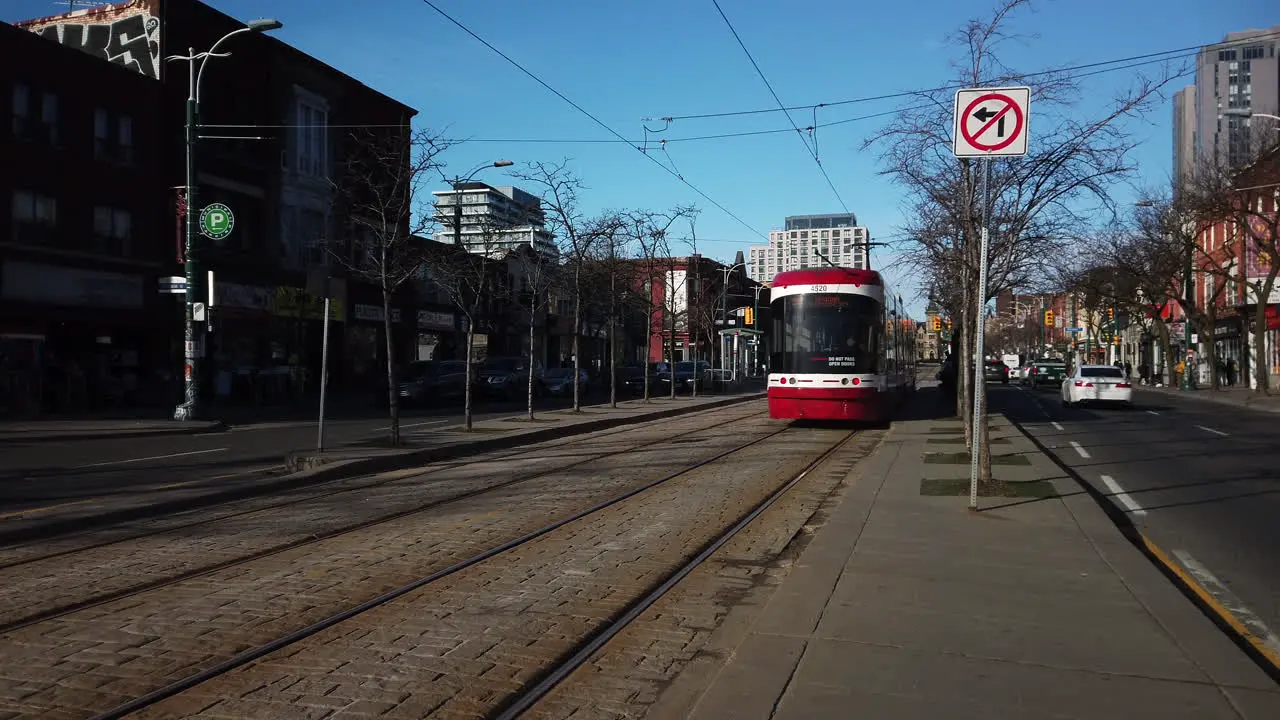 Wide shot of northbound streetcar passing by on Spadina Avenue in Toronto