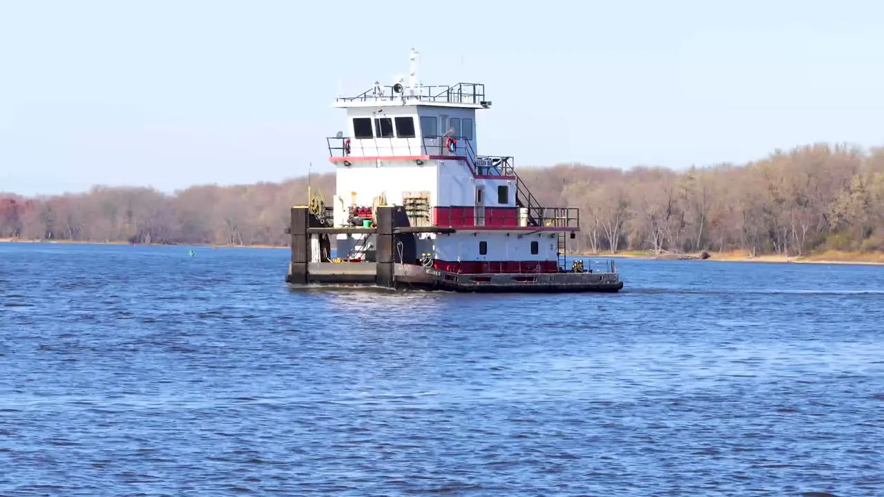 A close-up of an empty barge tug Moving pretty quick down the Mississippi river on an overcast fall day