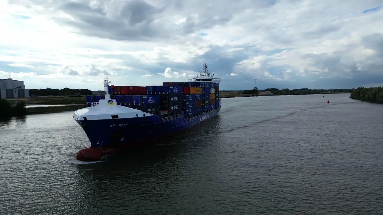 Orbit shot around big cargo ship with stacked naval containers sailing on river