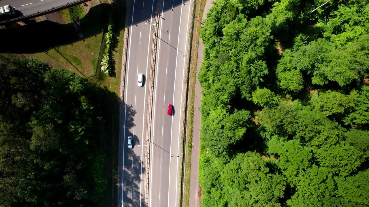 4K Aerial View Of Cars On Highway Overpass With Green Forest Next To It