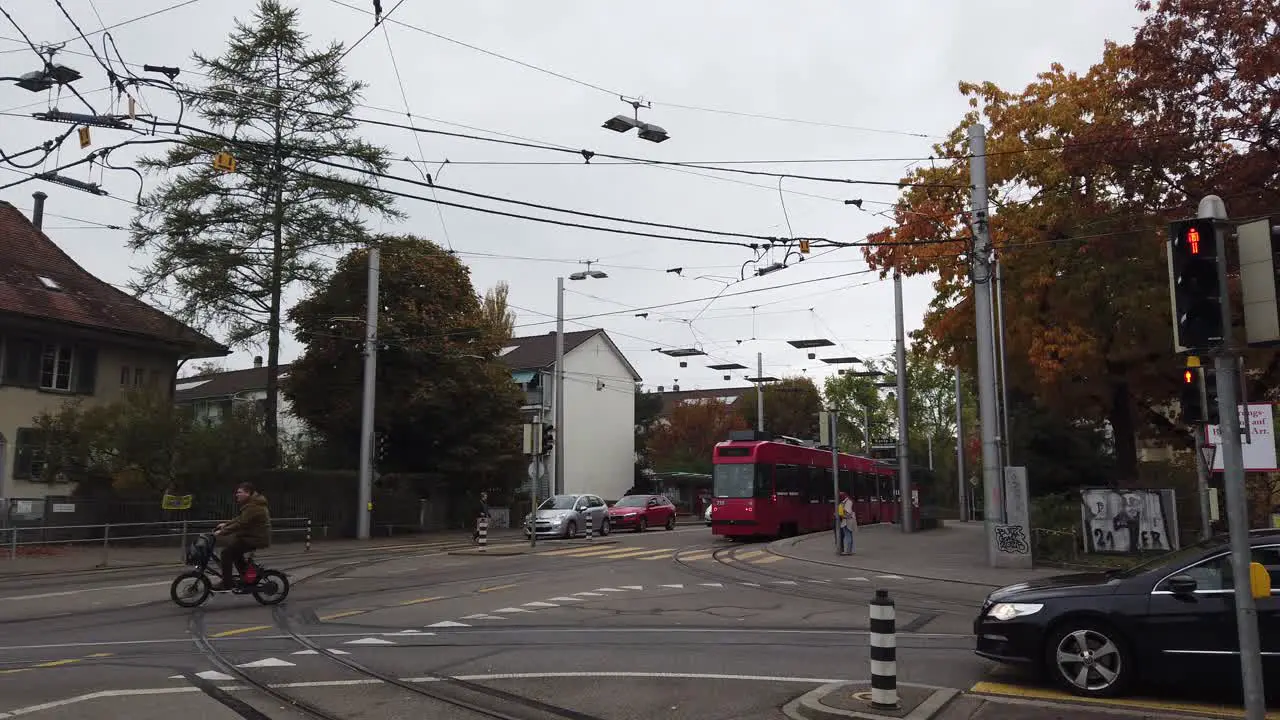 A Red Tram Rides the Streets of Bern Switzerland in Autumn Cars and Bicycles