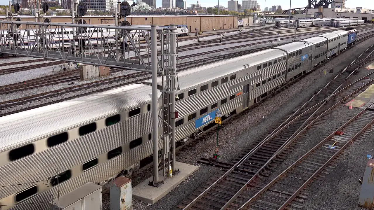 a locomotive pulling passenger train cars through rail yard 4k