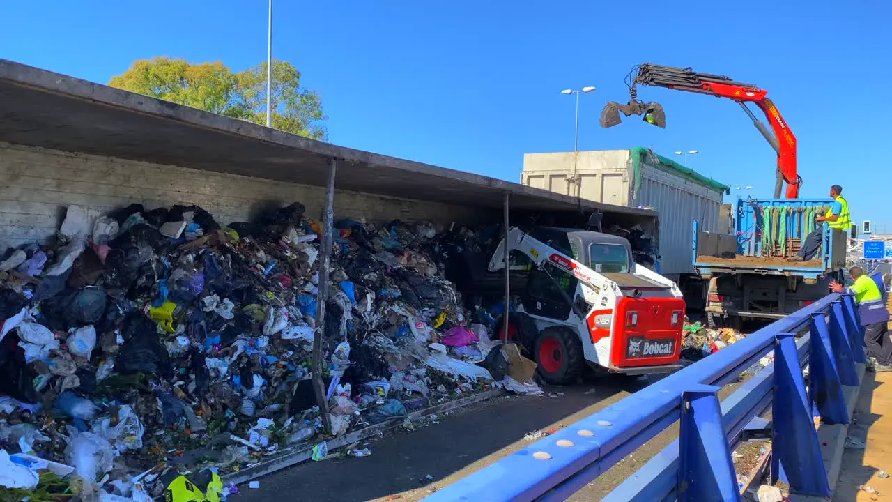 Big garbage trash truck crash on a highway being cleared up by emergency response vehicles and excavators tractors on the main road in Marbella Malaga Spain dangerous transport accident news story