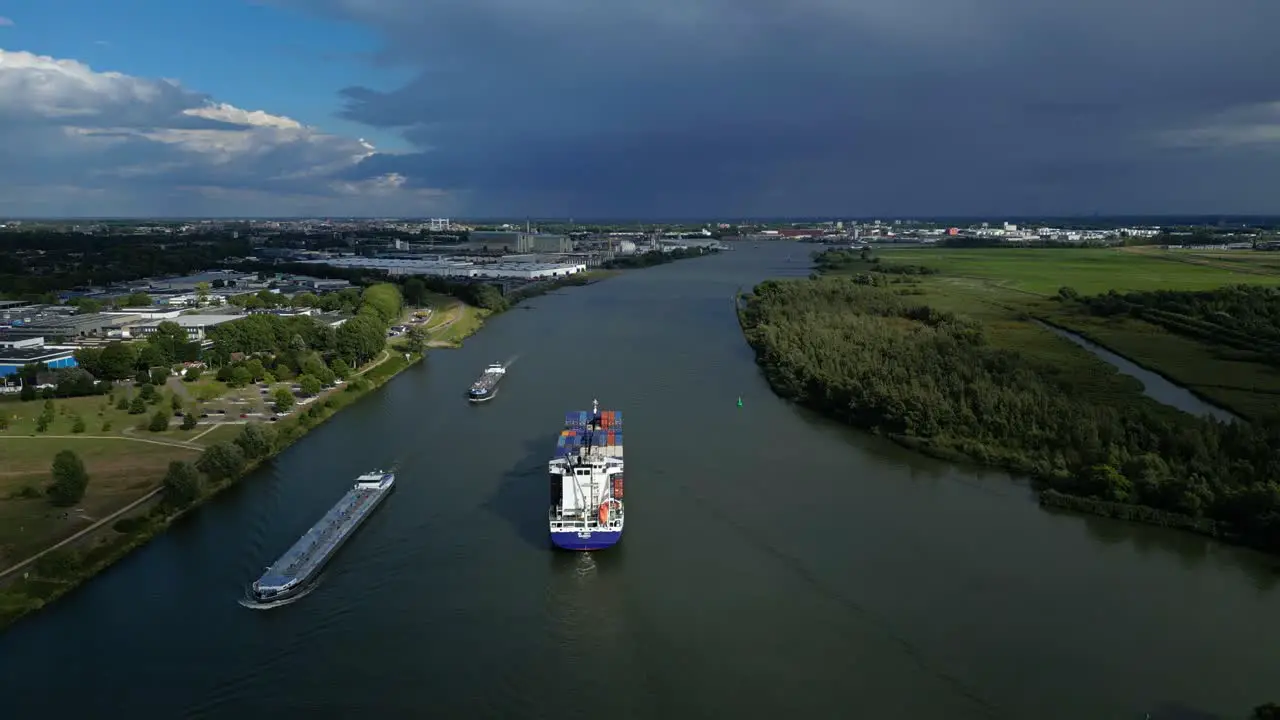 Aerial panoramic view of river with cargo ships and surrounding flat landscape