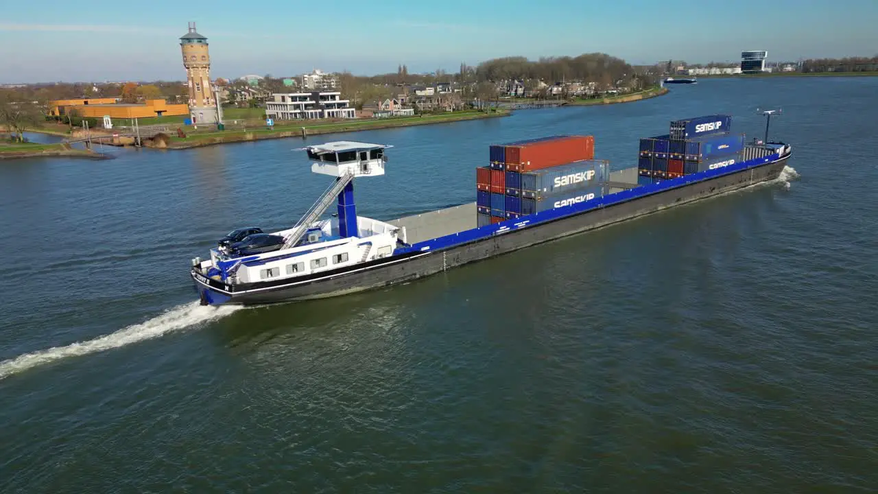 Aerial view Transportation ship with containers and cars moving past "De Oude Maas" Canal in Dordrecht the Netherlands