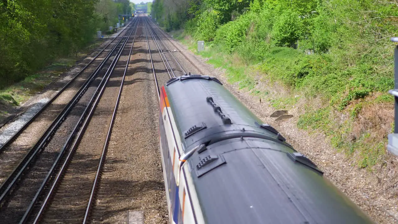 Three carriage South Western Train travelling on railway under bridge slow motion