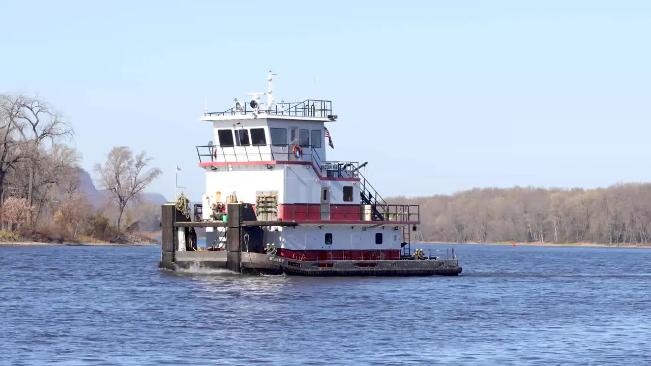 Close up of a barge moving down the Mississippi river with no cargo in the fall time