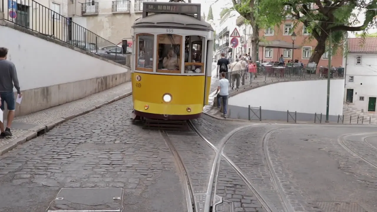 Electrico tram cruising trough the streets of Lisbon front tracking shot slow motion