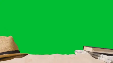 Summer Holiday Concept Of Book Sun Hat Beach Towel On Sand Against Green Screen 2