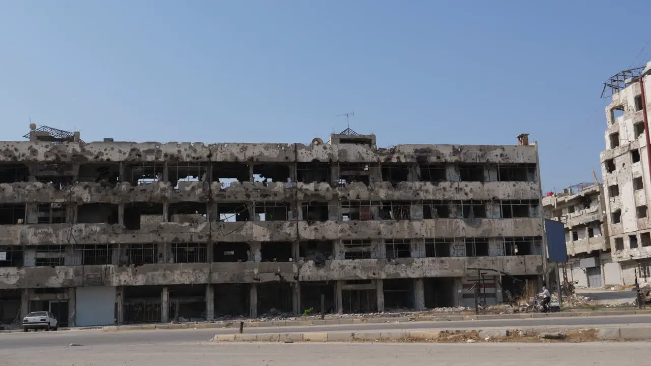 Steady shot cars passing the road old huge infrastructure damaged by Syrian civil war in Homs city