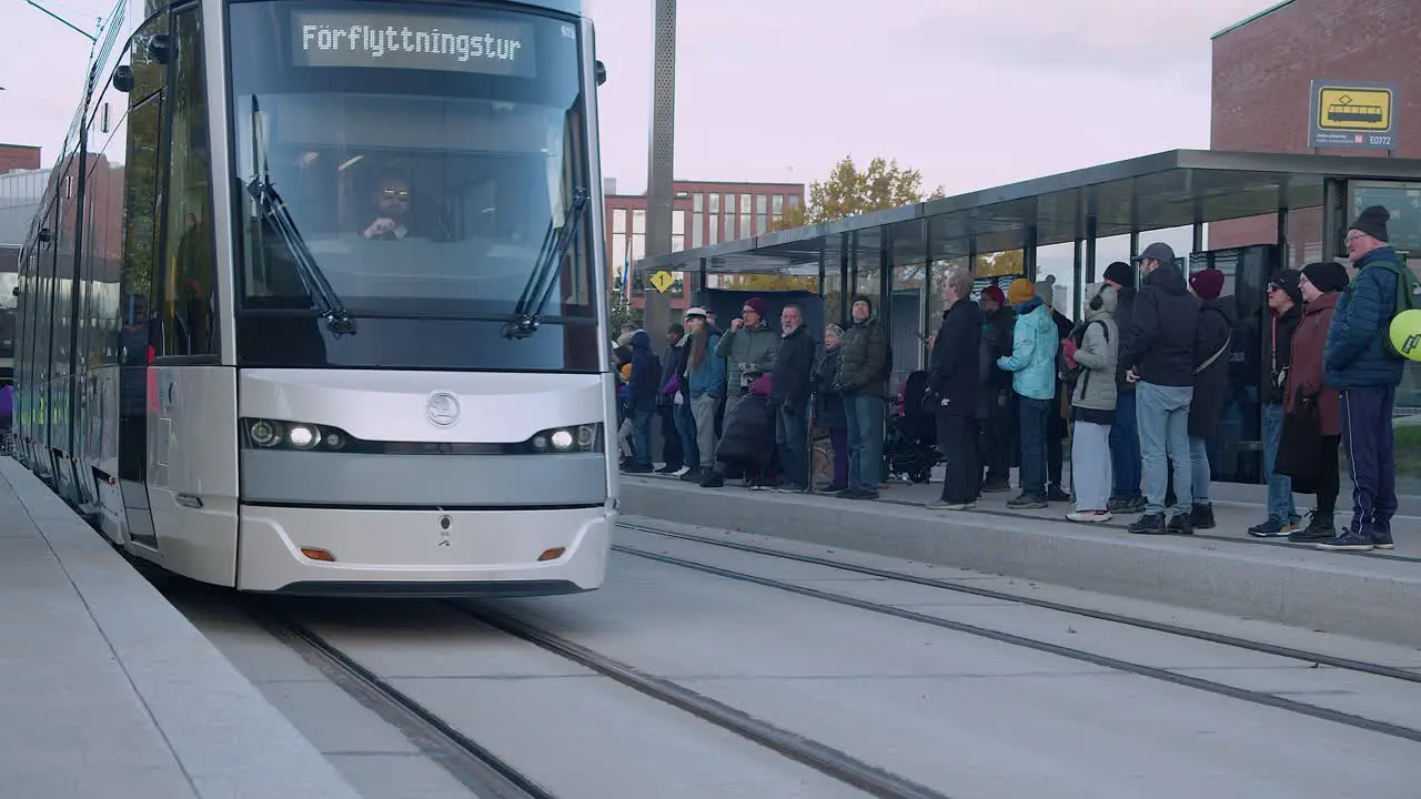 Bright clean commuter train arrives at Helsinki street tram platform