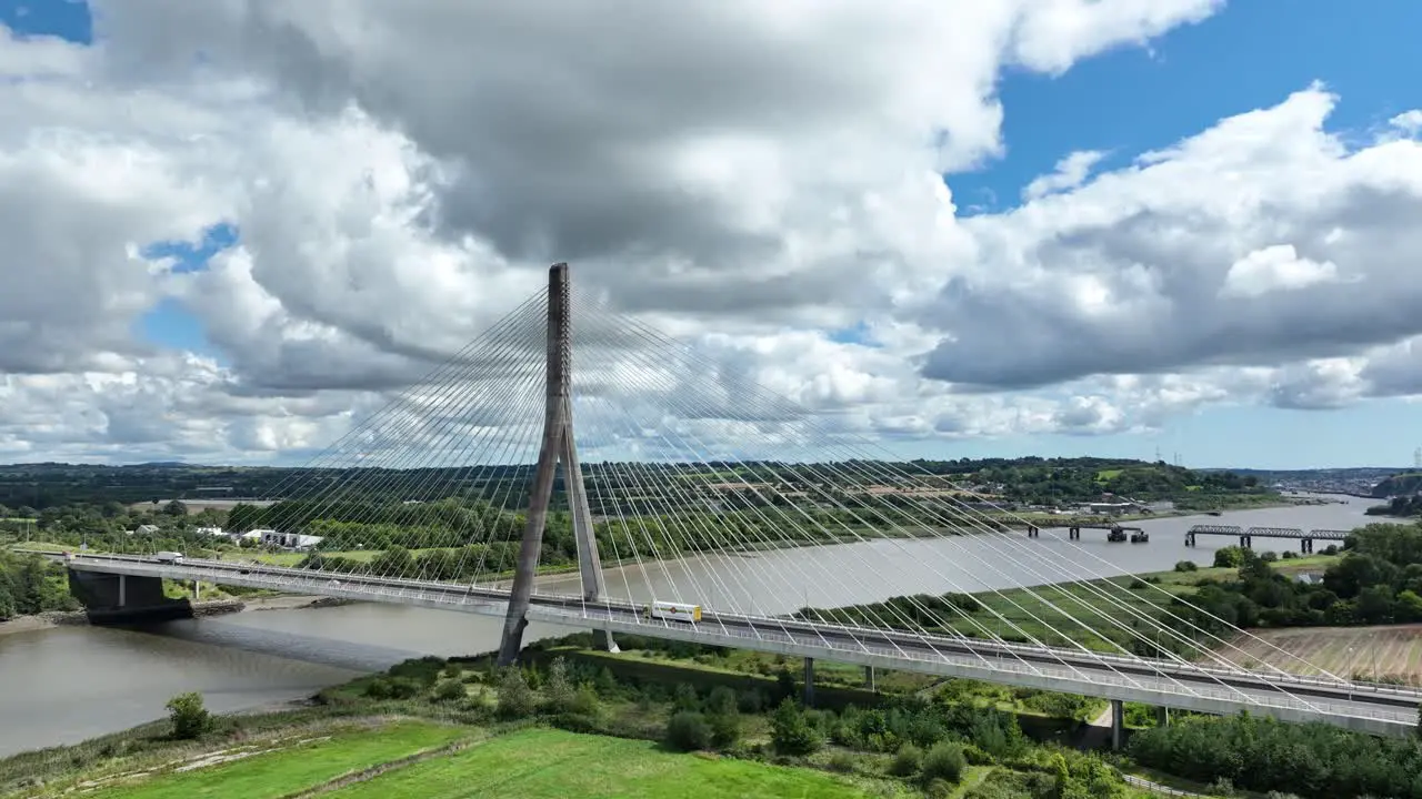 Drone panning shot of suspension Bridge in Waterford Ireland over the river Suir on a bright cloudy summer day