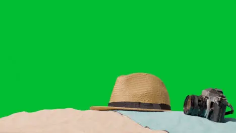 Summer Holiday Concept Of Sunglasses Sun Hat Camera Beach Towel On Sand Against Green Screen 2