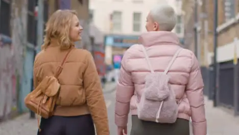 Tracking Shot Following Two Young Women Walking Down English Street