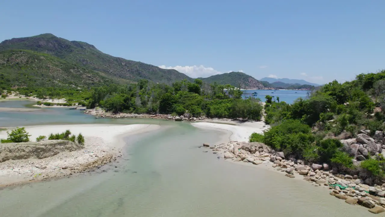 Drone flying above the backwaters and green cliffs around sea of Binh Tien Beach in Vietnam