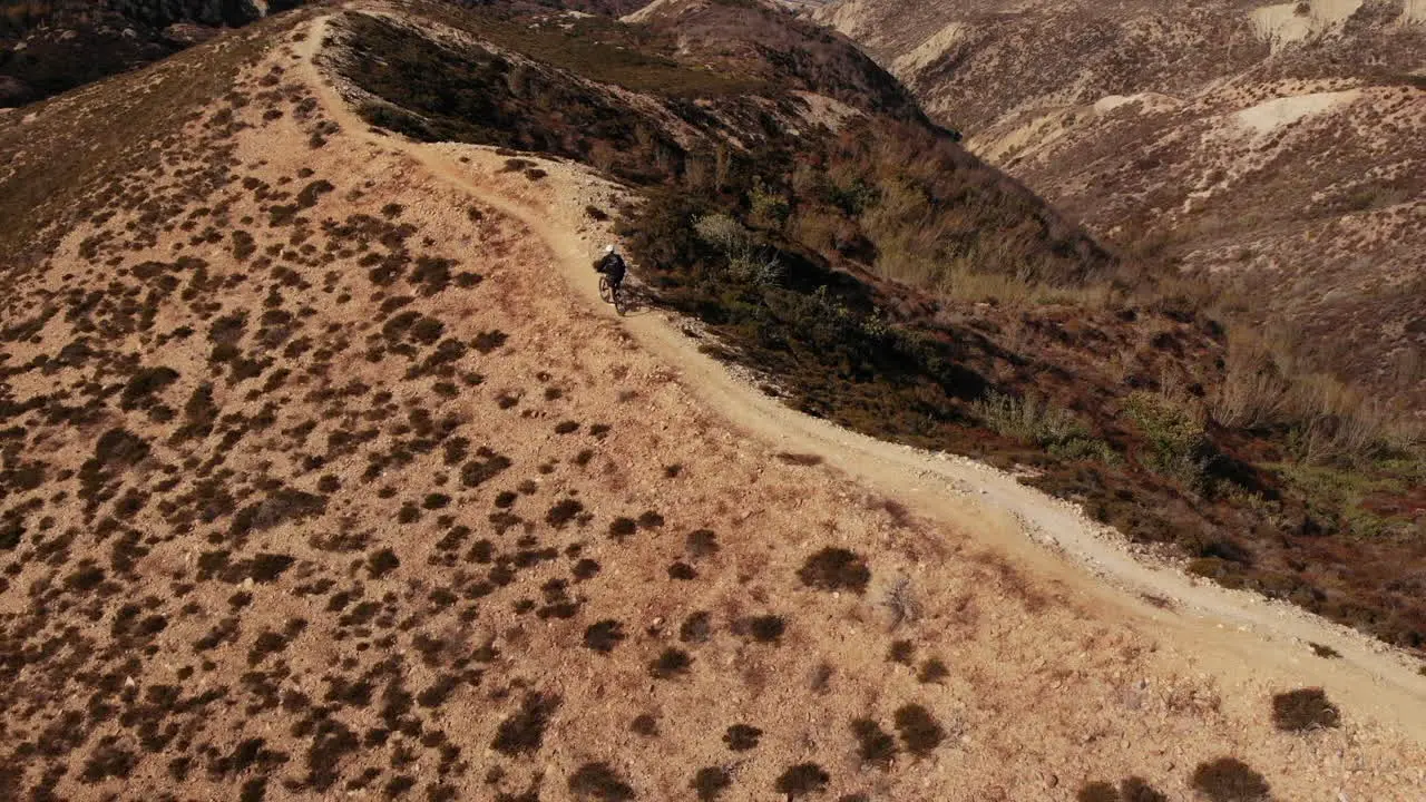 Man riding bike in the mountain with black outfit near the beach