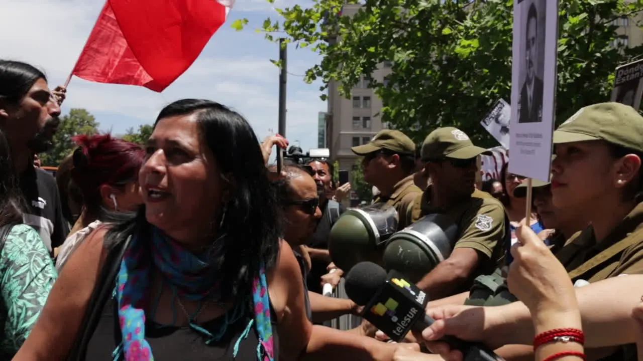 Protester stand at a barricade of military enforcers in the streets of Santiago