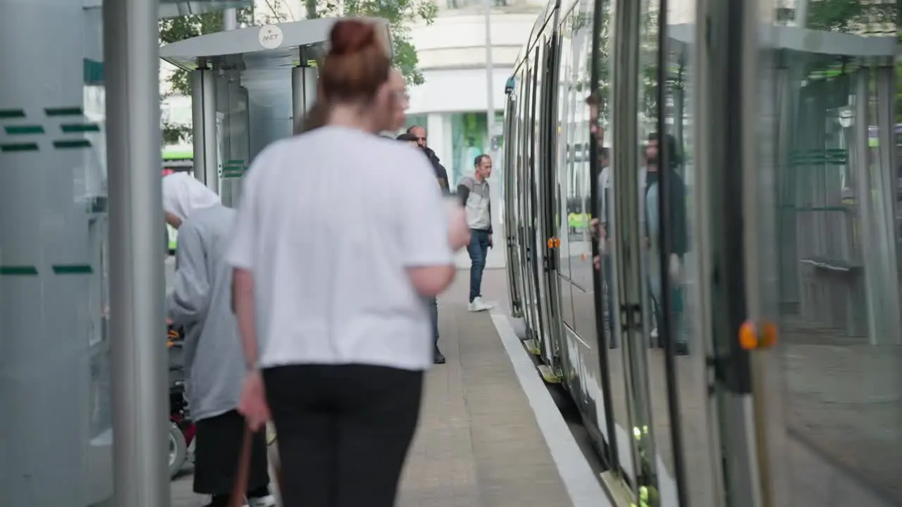 Tourists and locals exiting and entering city tram in slow motion close up scene