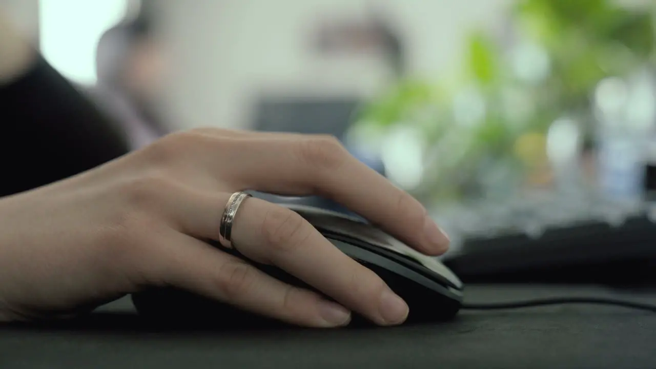 Hand using a mouse on a desk in an office selective focus scrolling and clicking