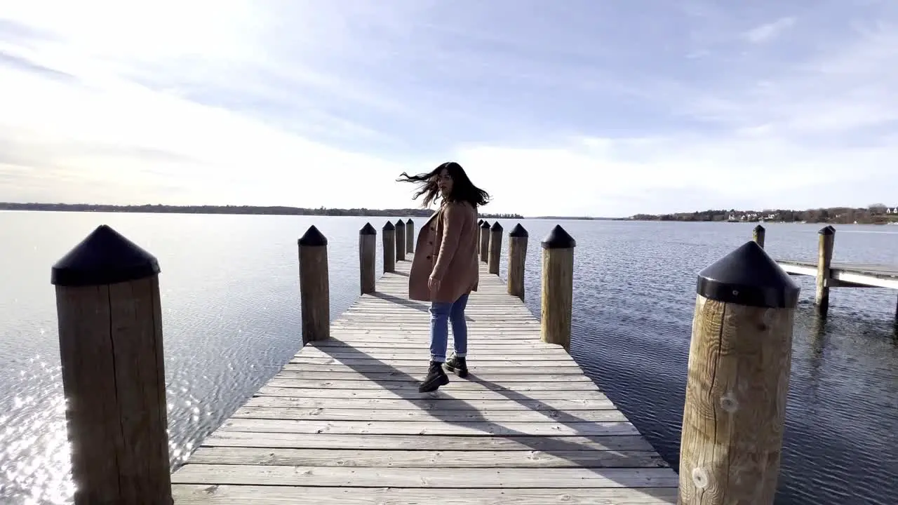 Girl walking on a deck pier at a lake