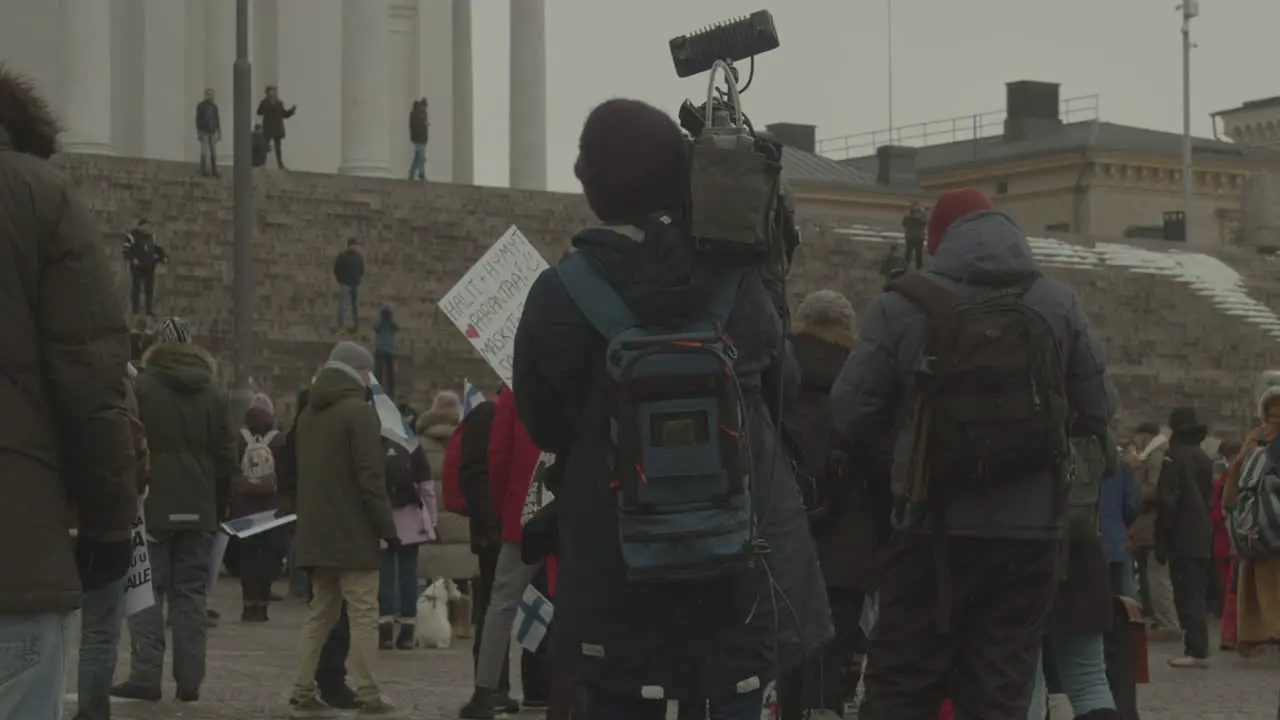 Reporter filmed a large group of protesters with a professional camera on a cold winter day