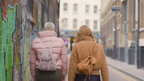 Medium Shot of Two Young Women Walking Down English Street