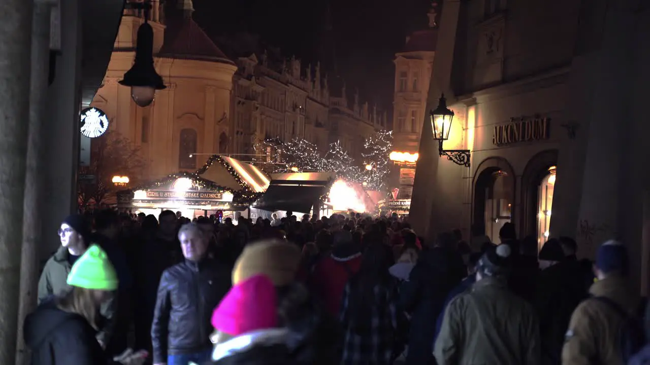 Crowd heading to Christmas market in decorated Prague streets at night