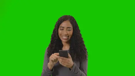 Woman Looking At Mobile Phone And Celebrating Good News Against Green Screen