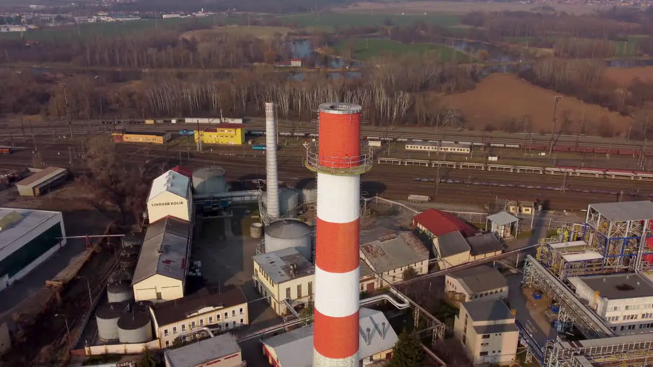 aerial view of an industrial chimney with a train in the background flyover