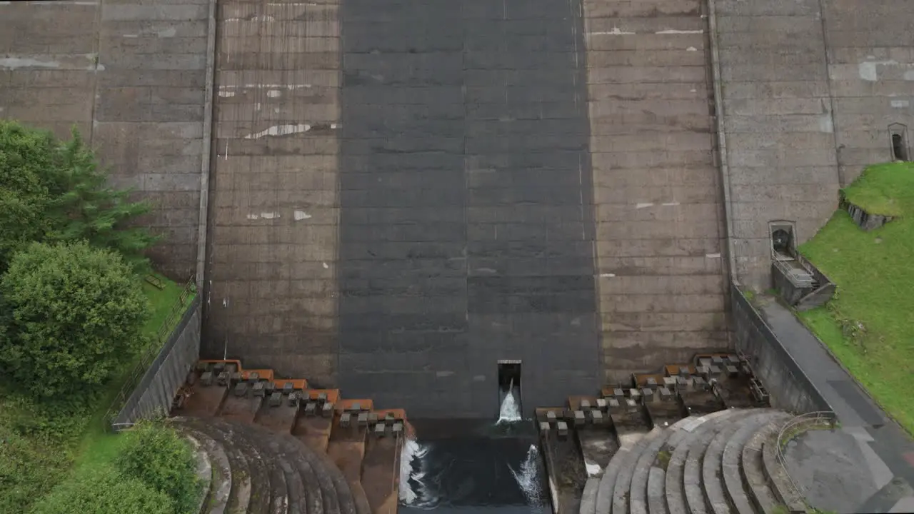 Booth wood reservoir aerial view descending tilt up concrete dam spillway construction in West Yorkshire England