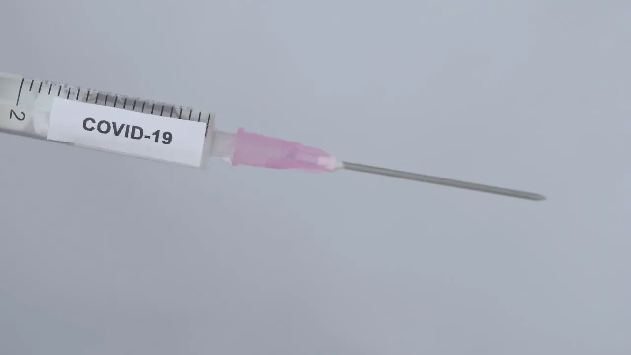 Hand Of A Physician Removes The Needle Cap Of Syringe With COVID-19 Vaccine