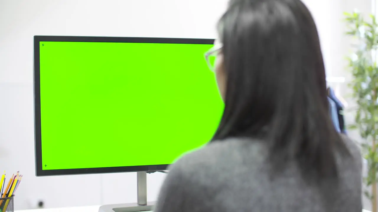 Tracking Past Woman Working at Computer Chroma Screen