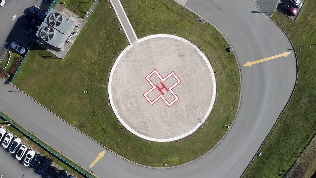 Aerial Overhead View of a Helipad at a Hospital Drone Rising Spin Shot on a Sunny Day