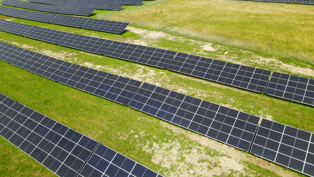 Aerial view of green field with solar energy panels for renewable electricity production