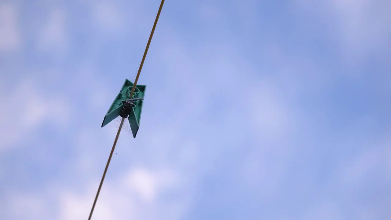 Plastic Clothespin On A Clothesline Against Cloudy Sky