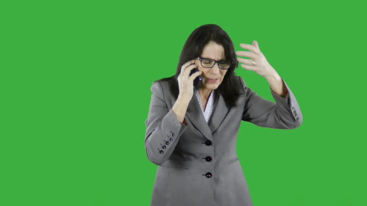 Angry mature businesswoman receives bad news while talking on her cell phone