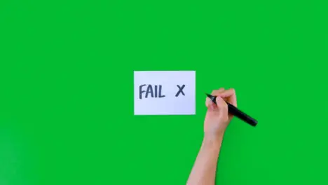 Woman Writing Fail with a Cross on Paper with Green Screen