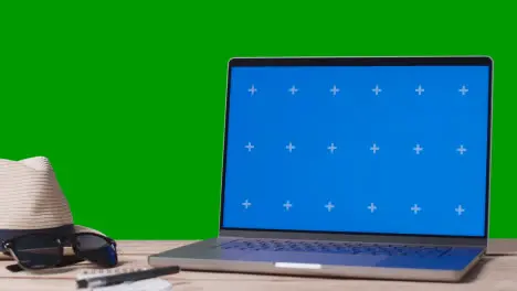 Blue Screen Laptop On Table With Holiday Accessories And Green Screen Background