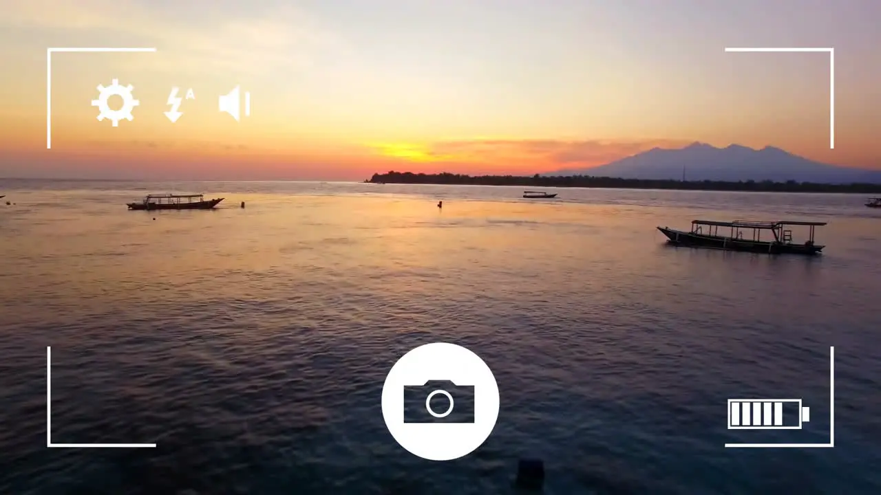 Animation of digital camera interface screen over boats on ocean at sunset