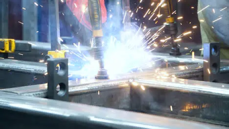 Welder fastening together massive metal parts in welding process