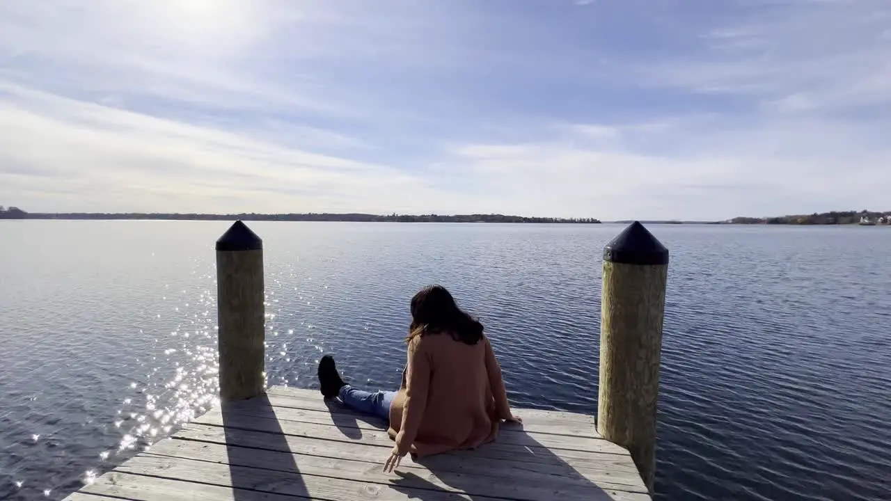 Girl with a cute autumn outfit seated on a boat launching deck