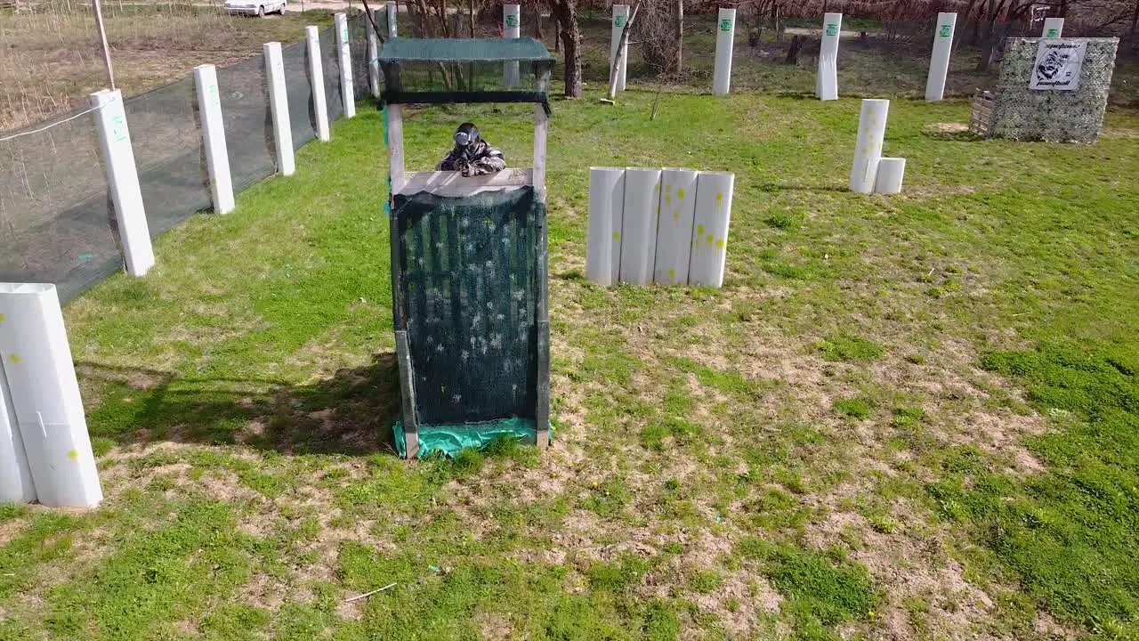 Paintball player fires at the opponents and hides in a tower