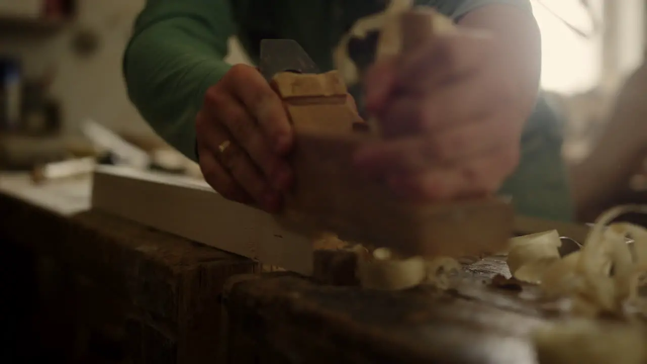 Unknown carpenter using plane in workshop Craftmaster hands preparing plank