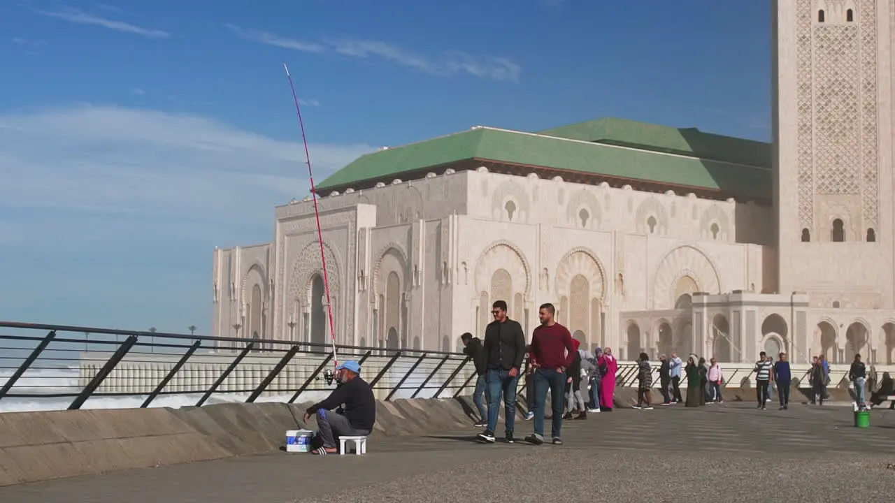 Moroccan people walking in front of Hassan II mosque Casablanca Morocco